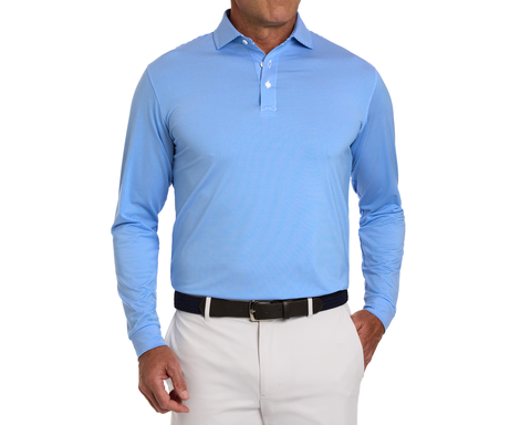 Man wearing The Burke Shirt: Horizon Blue & White, a light-blue long-sleeve polo with fine stripes, tucked into light trousers, showcasing comfort and sun protection.