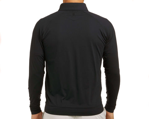 Back view of The Westland Quarter-Zip: Black, showcasing the fit and styling with a small logo below the collar, paired with light-colored bottoms.