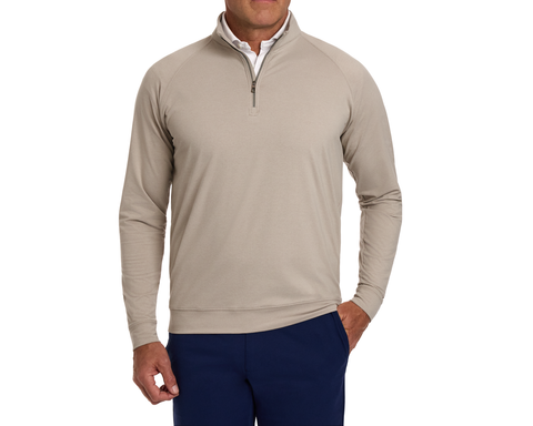 Man wearing The Westland Quarter-Zip: Heathered Dune, showcasing its athletic cut and gunmetal chrome trim, layered over a white shirt.