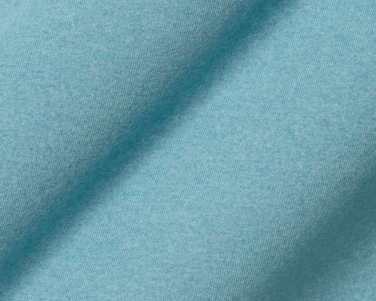 Close-up of The Westland Quarter-Zip: Heathered Harbor, showcasing its knit-textured, light blue fabric known for softness and moisture-wicking performance.