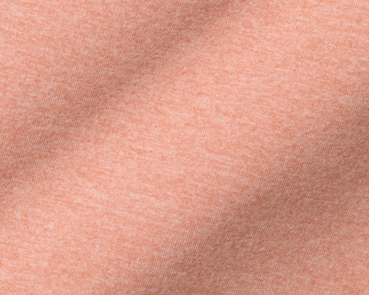 The Westland Quarter-Zip: Heathered Nectarine features soft, peach-colored knit fabric with fine weave and gentle folds, showcasing its lightweight, moisture-wicking properties.