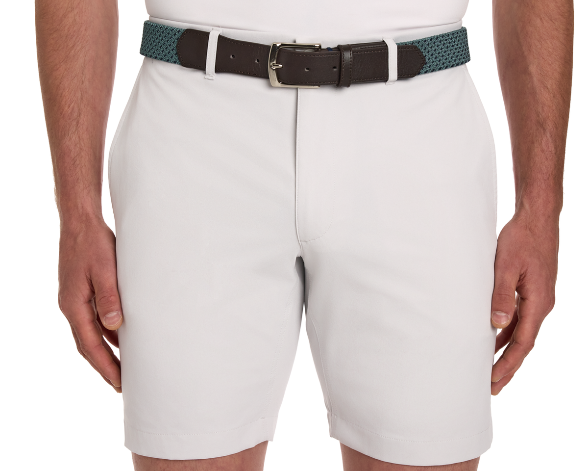 The Fischer Belt: Dark Harbor & Navy Basketweave, woven teal-green with dark brown leather ends and metal buckle, complements light-gray knee-length shorts.