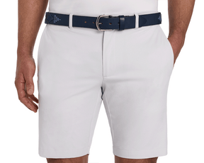 The Barker Belt: Navy & Slate, featuring intricate Argentinean-inspired patterns, is shown threaded through light-gray shorts, paired with a tucked-in white shirt.