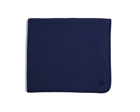 The Van Pelt Blanket: Heathered Navy; a folded, navy blanket with a piped border and tonal embroidered logo, ideal for cozy evenings.