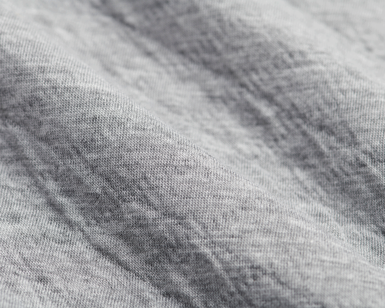 The Van Pelt Blanket: Heathered Gray, close-up of soft, knit fabric texture, showcasing its looped weave, ideal for cozy, stylish comfort.