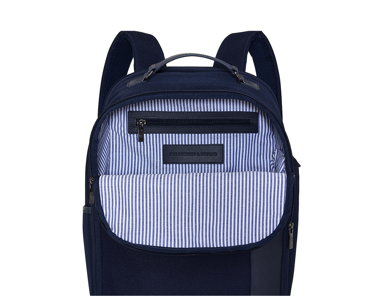 The Broughton Backpack: Navy Ballistic, features an unzipped front pocket revealing a striped lining, zippered inner pocket, and leather patch stamped “HOLDENNESS & BOURNE.”