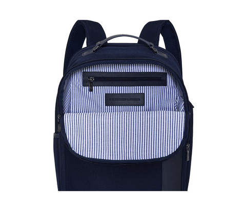The Broughton Backpack: Navy Ballistic, features an unzipped front pocket revealing a striped lining, zippered inner pocket, and leather patch stamped “HOLDENNESS & BOURNE.”