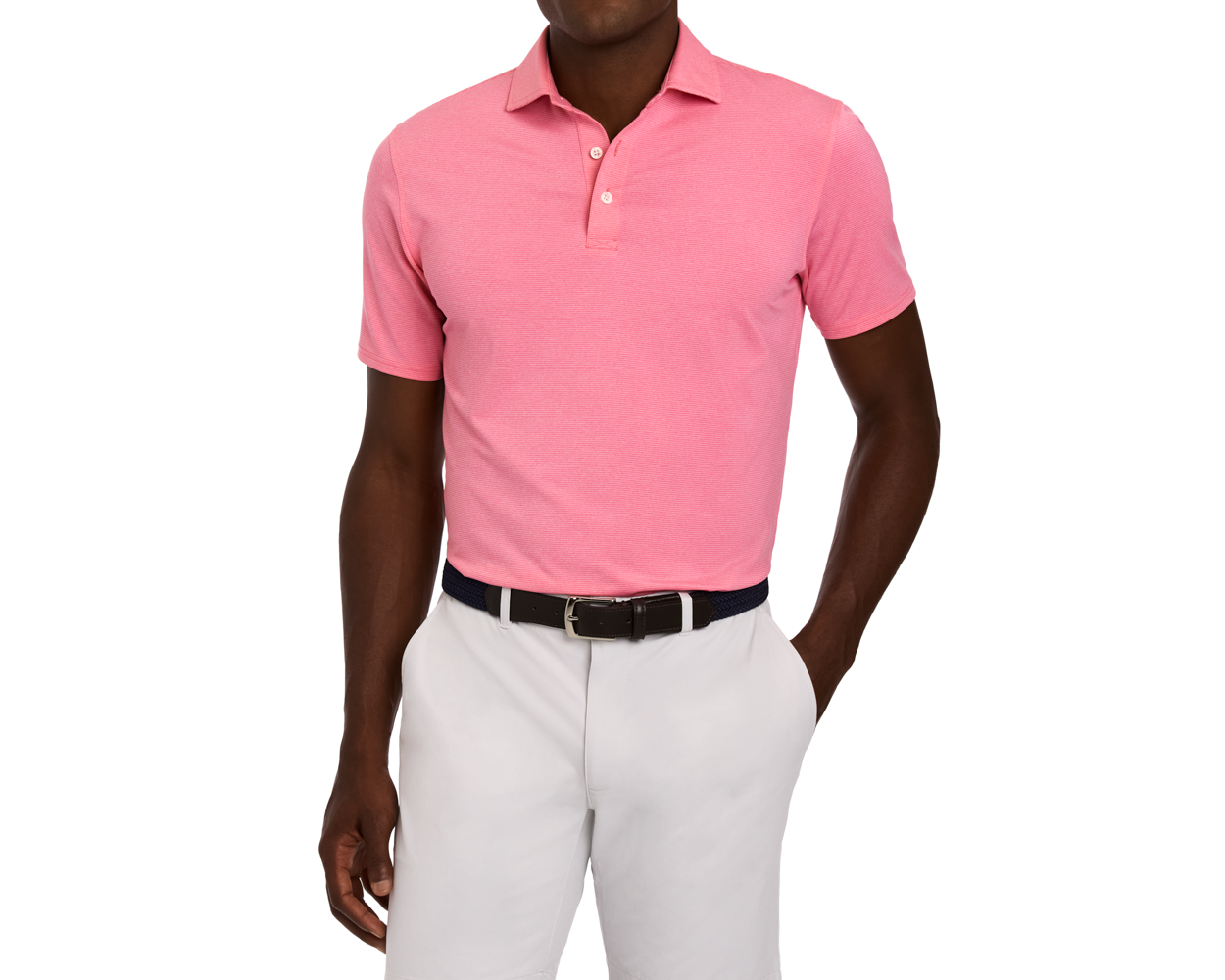 Man wearing The Holland Shirt: Heathered Belmont, a short-sleeve pink polo with subtle stripes, tucked into light-gray trousers, complemented by a black woven belt.