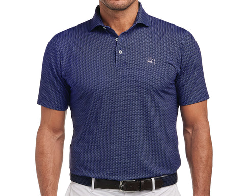 Man wearing Yale Golf Course Frame Shirt: Navy & White, featuring a small visor pattern and bulldog logo, tucked into light trousers with a woven belt.
