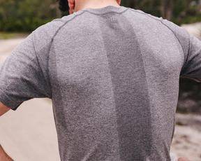 Back view of The Pickett Performance T-Shirt in heathered gray, featuring a textured stripe, showcasing its athletic fit and breathable AIRATION® fabric outdoors.