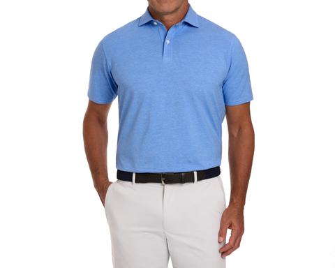 Model wearing The Hatcher Shirt in Horizon Blue, a short-sleeve polo made of soft Peruvian Pima cotton, tucked into light trousers with a dark belt.