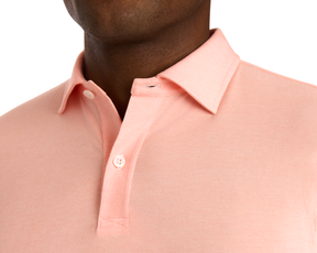 Close-up of The Hatcher Shirt: Nectarine & White, showcasing its light peach cotton polo design with a folded collar and partially open two-button placket.