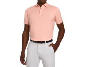 Male model wearing The Hatcher Shirt: Nectarine & White, a short-sleeve polo with a structured collar, tucked into light gray trousers, featuring a dark woven belt.