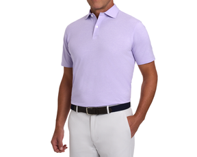 Man wearing The Hatcher Shirt: Tudor & White, a short-sleeve polo made from soft Peruvian Pima cotton, tucked into light trousers with a dark belt.