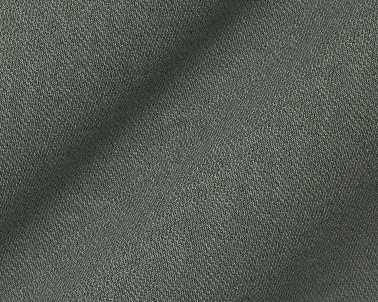 Close-up of The Neville Shirt: Ivy, showcasing its knitted jersey-style fabric with a distinctive V-stitch pattern, highlighting the shirt's soft, durable texture.