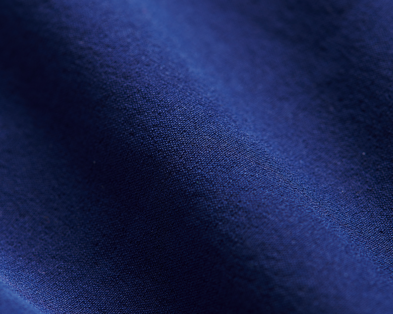 Close-up of The Harwood Short: Navy, showcasing its fine woven texture and gentle folds, highlighting the fabric's softness and performance features for golfers.