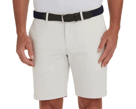 The Harwood Short: Stone, featuring a non-slip waistband and ball-marker pocket, worn with a dark navy belt, offers classic style and performance.
