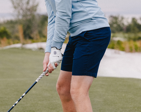 The Cameron Short: Navy, worn on a golf course, showcasing durability and stretch for unrestricted movement, featuring a luxuriously soft, garment-washed finish.