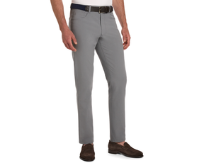 The McDaniel 5 Pocket Pant: Light Gray, slim-fit, worn with a dark woven belt and brown suede loafers, showcasing wrinkle-resistant, quick-dry fabric with eco-friendly stretch.