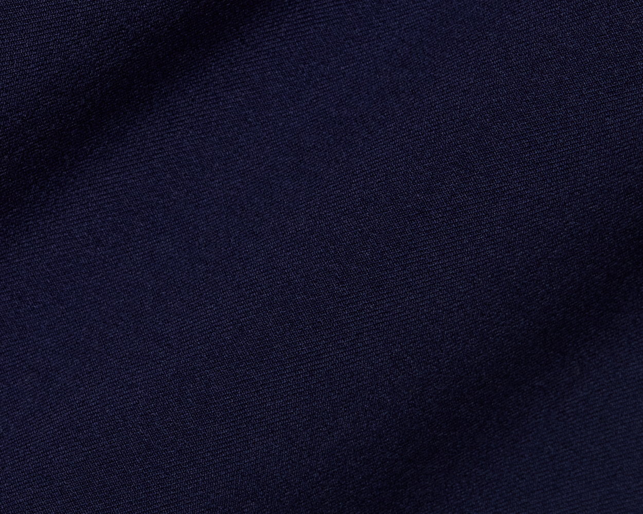 Close-up of The McDaniel 5 Pocket Pant: Navy, showcasing its fine woven texture, highlighting wrinkle-resistant, quick-dry performance fabric with eco-friendly recycled polyester and elastane blend.