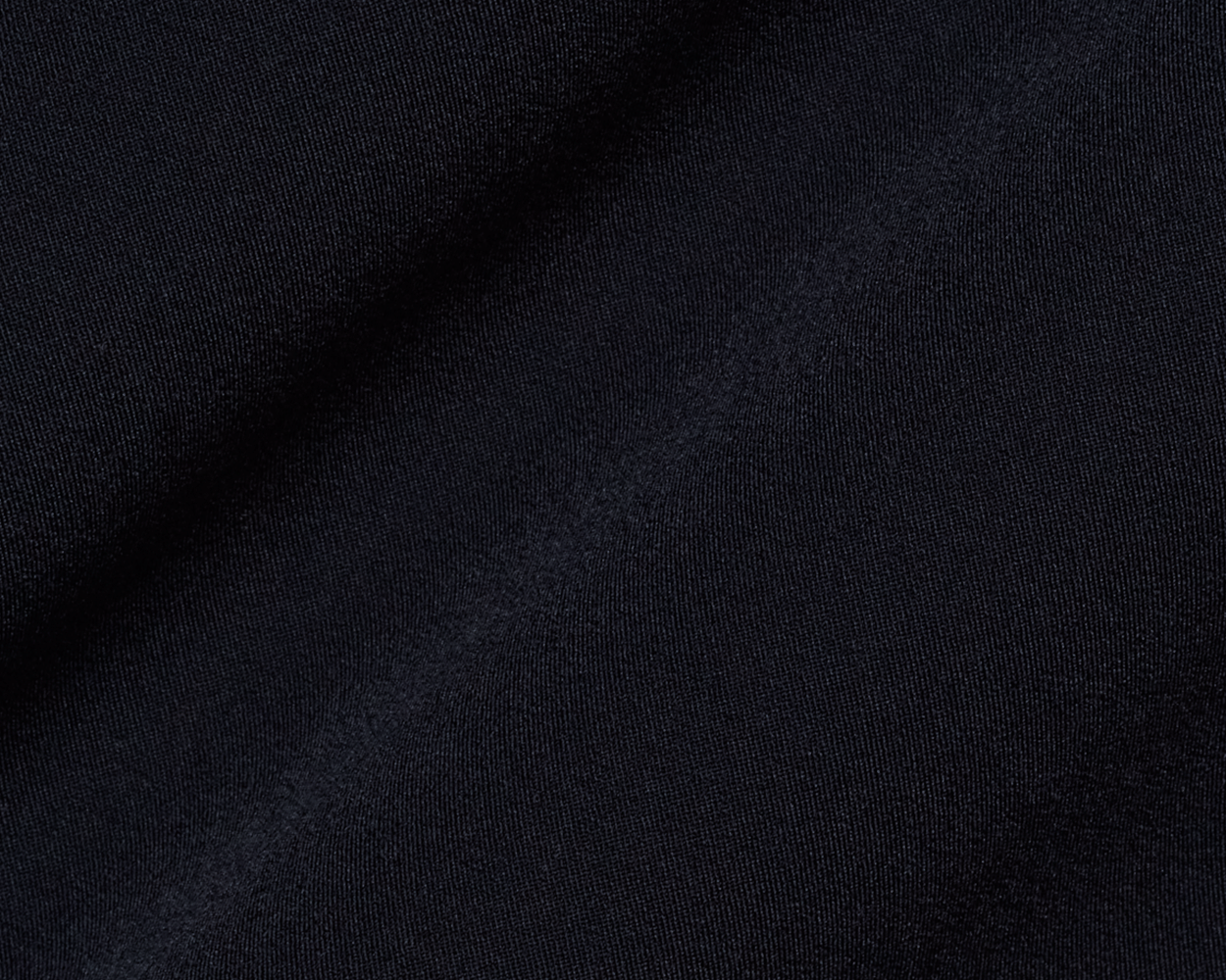 Close-up of The Saunders Short: Black, showcasing its fine knit texture and subtle folds, highlighting its quick-drying, stretchable fabric designed for optimal performance.