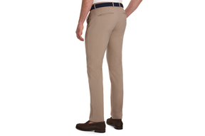 The Anson Chino Pant: Fescue, featuring slim-fit design with slant pockets, a dark woven belt, and brown suede loafers for polished on-course style.