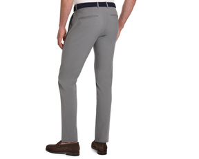 The Anson Chino Pant: Light Gray, slim-fit trousers with slant pockets, worn with a white shirt, dark belt, and brown loafers, showcasing wrinkle-resistant performance fabric.