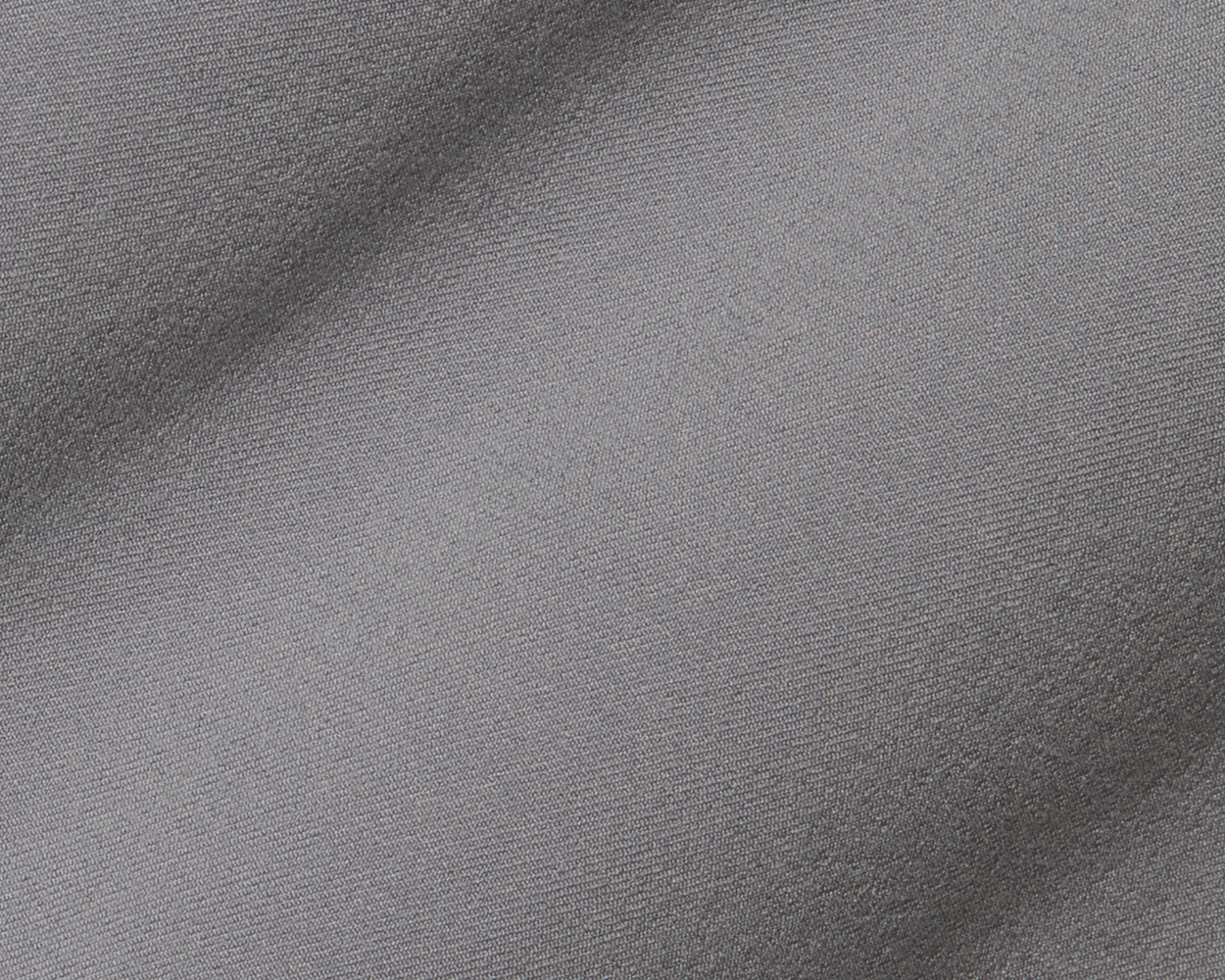 Close-up of The Anson Chino Pant in light gray, showcasing its smooth fabric texture and subtle wrinkles, highlighting its eco-friendly, wrinkle-resistant performance material.