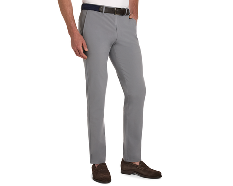 Man wearing The Anson Chino Pant in light gray with a black belt and dark brown loafers, showcasing wrinkle-resistant, quick-dry, eco-friendly fabric with four-way stretch.