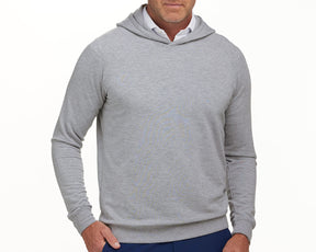 The Lawson Hoodie: Heathered Gray, slim-fit, light-gray with no drawstrings, worn over a white collared shirt, hand in dark blue pants pocket.