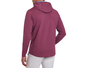 The Jackson Hoodie: Cabernet shown from the back, features a lightweight, hooded design without drawstrings, perfect for golf. Paired with light-grey pants.