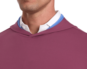 The Jackson Hoodie: Cabernet, layered over a white shirt and light blue garment, showcases a sleek design suitable for golf, emphasizing comfort and minimalism.