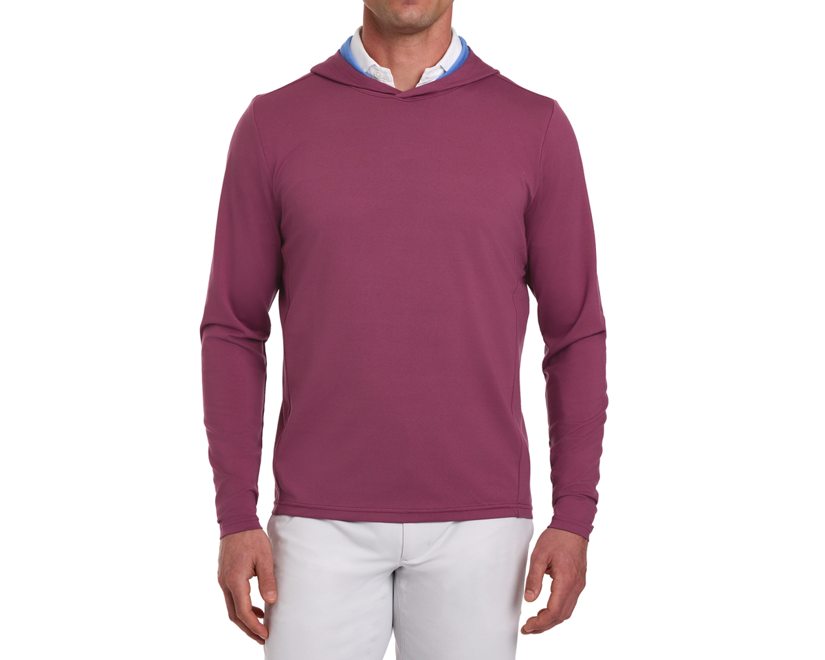 The Jackson Hoodie: Cabernet, shown on a male model, is a slim-fit, long-sleeve hoodie over a collared shirt, paired with light pants.