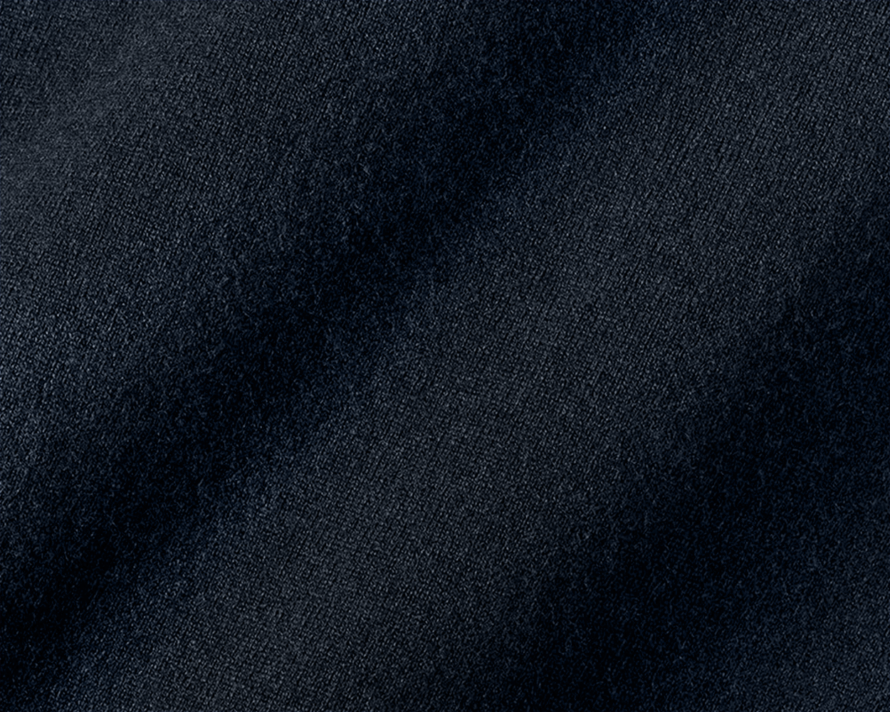Close-up of The Buckley Crewneck Sweater in Heathered Dark Navy, showcasing 100% Scottish cashmere with a fine diagonal weave pattern and classic crewneck styling.