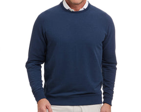 Man wearing The Kennedy Crewneck: Heathered Atlantic, a navy-blue sweatshirt over a white collared shirt. Offers comfort with its plush terry interior.