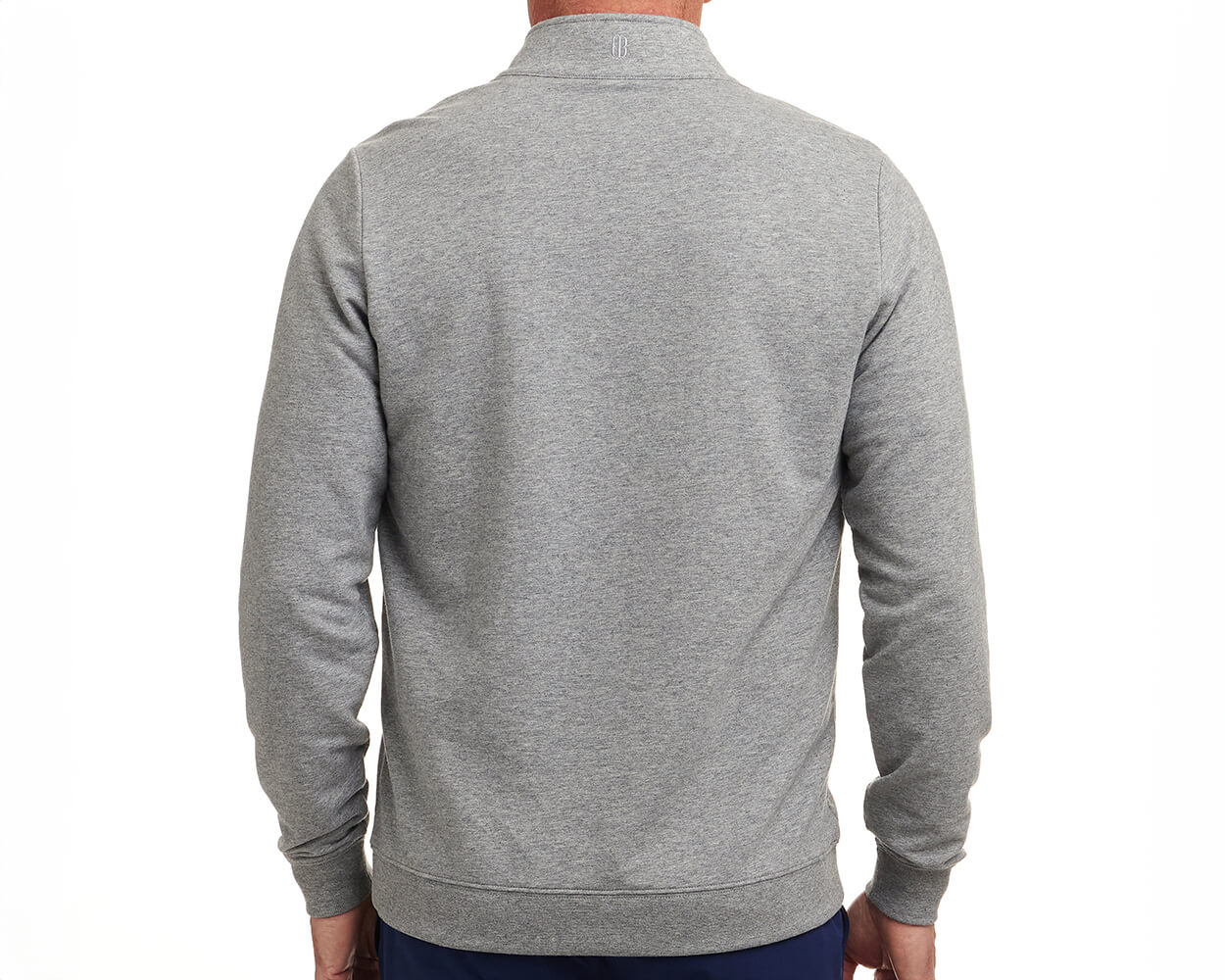 Back view of The Harper Quarter-Zip: Heathered Gray, showcasing its logo below the collar, ribbed cuffs, and hem, worn with dark pants.