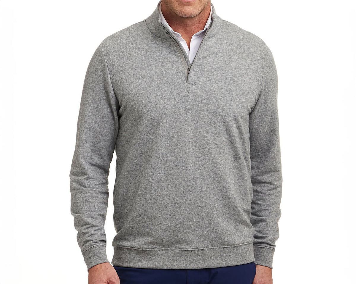 Model wears The Harper Quarter-Zip in heathered gray, featuring a soft terry interior, ribbed cuffs, and hem, styled over a white shirt.