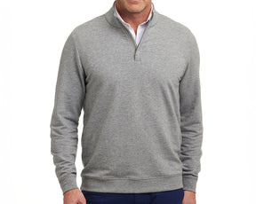 Model wears The Harper Quarter-Zip in heathered gray, featuring a soft terry interior, ribbed cuffs, and hem, styled over a white shirt.