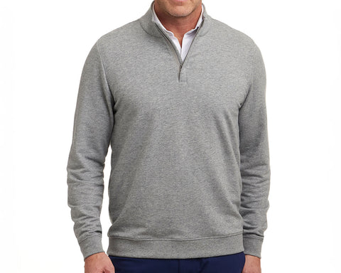 Model wears The Harper Quarter-Zip in heathered gray, featuring a soft terry interior, ribbed cuffs, and hem, styled over a white shirt.