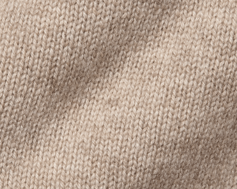 The Berwick Crewneck Sweater: Heathered Dune, close-up of plush, three-ply Scottish cashmere in stockinette stitch, showcasing premium craftsmanship and texture.