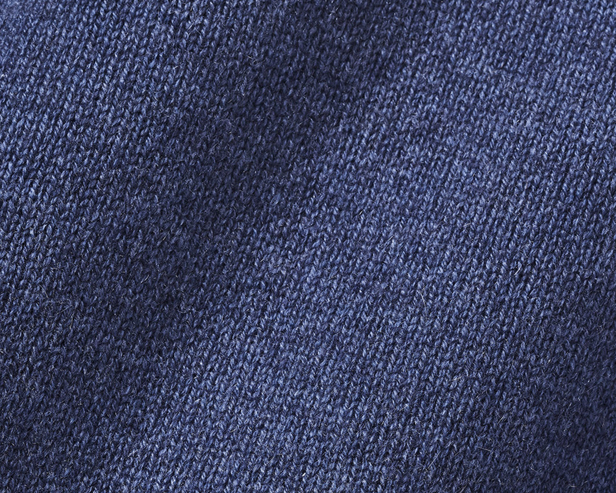 Close-up of The Berwick Crewneck Sweater: Heathered North Sea, showcasing its blue knitted texture with plush, three-ply cashmere and reinforced cuffs.