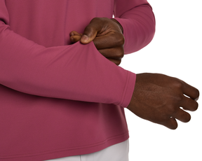 Person wearing The Stuart Quarter-Zip: Cabernet, featuring a ribbed texture, lightly grasping the sleeve. The luxurious fabric highlights its soft, performance-oriented design.