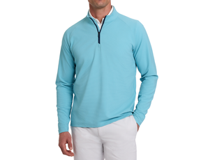 The Stuart Quarter-Zip: Harbor, featuring a light blue textured knit over a white shirt, paired with white pants, showcasing its versatile, modern style.