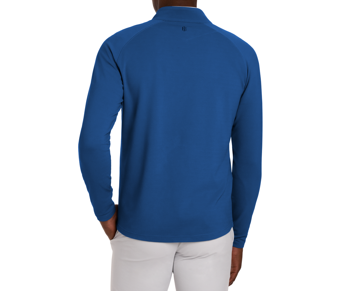 The Stuart Quarter-Zip: Maidstone Blue top showcases a fold-over collar, subtle back logo, paired with gray trousers, highlighting performance fabric and versatile style.