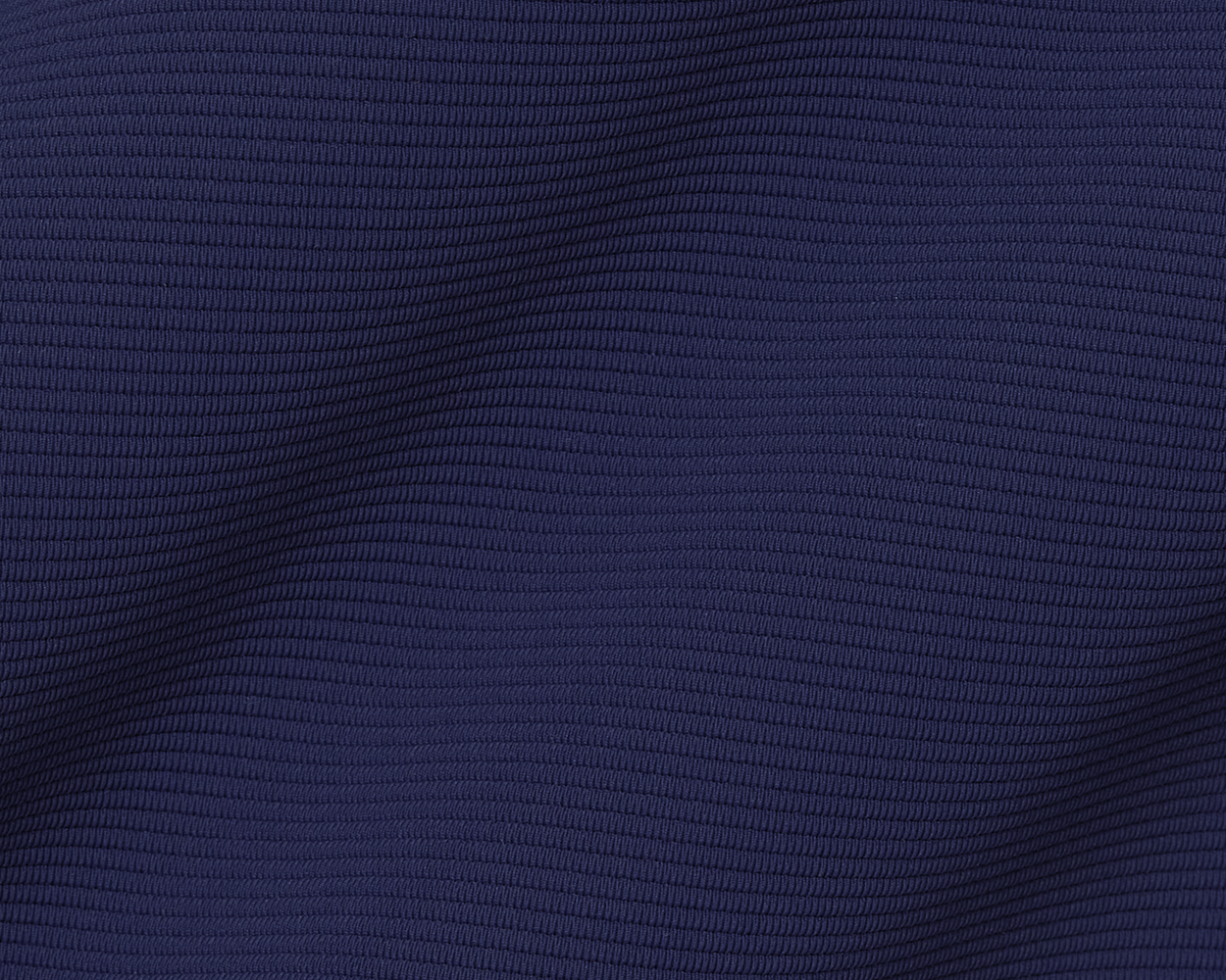 The Stuart Quarter-Zip: Navy features a close-up of its ribbed texture, highlighting the gentle folds and luxurious lightweight performance fabric.