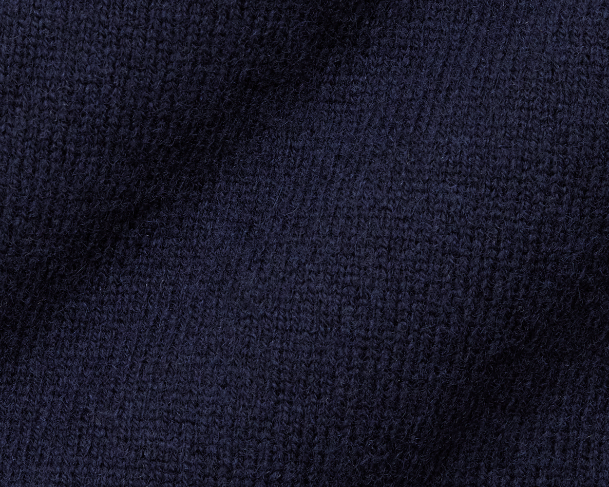 The Logan Hoodie Sweater: Heathered Navy, featuring a close-up of soft, dark-navy knit fabric with visible stitches, showcasing its luxurious Merino wool-cashmere blend.