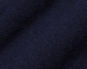 The Logan Hoodie Sweater: Heathered Navy, featuring a close-up of soft, dark-navy knit fabric with visible stitches, showcasing its luxurious Merino wool-cashmere blend.