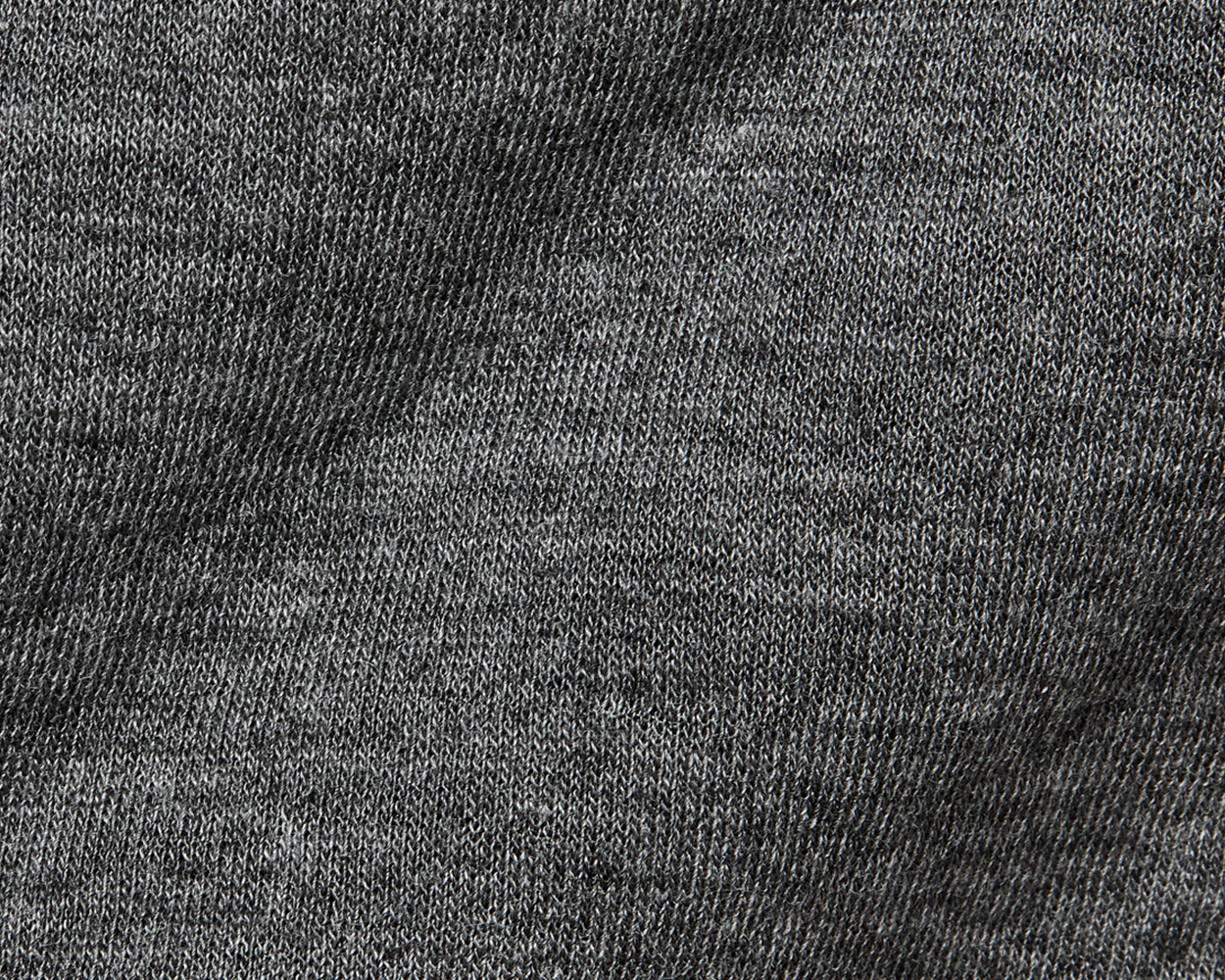 The Sullivan Quarter-Snap: Heathered Charcoal features close-up of soft, heathered knit fabric with visible stitches, highlighting its quilted insulation and classic style.