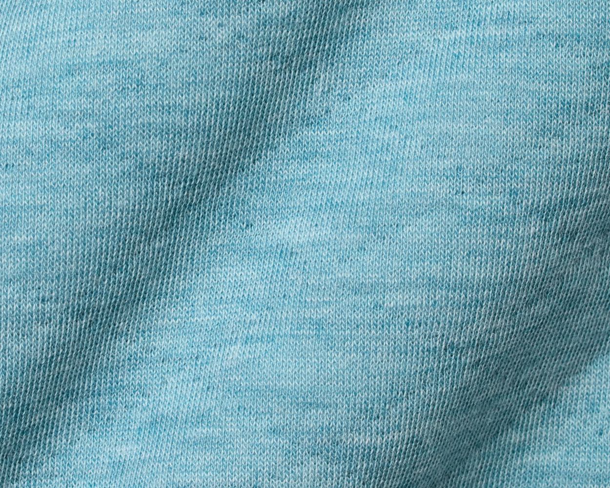 Close-up of The Sullivan Quarter-Snap: Heathered Harbor, showcasing its soft, light-blue knit texture with visible loops, highlighting its casual, quilted design.