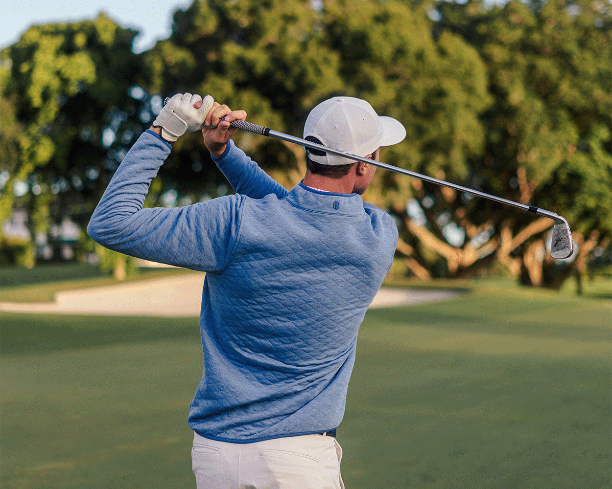 Golfer in The Sullivan Quarter-Snap pullover, showcasing its quilted design and casual style on a fairway, highlighting its versatility and performance.
